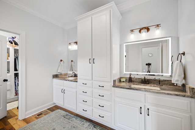 bathroom with hardwood / wood-style floors, vanity, and ornamental molding