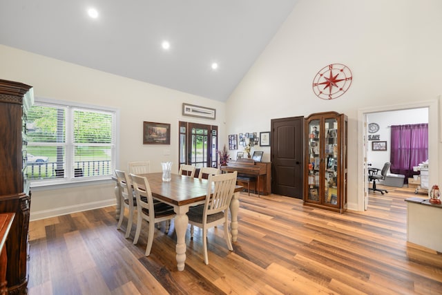 dining room with hardwood / wood-style floors and high vaulted ceiling