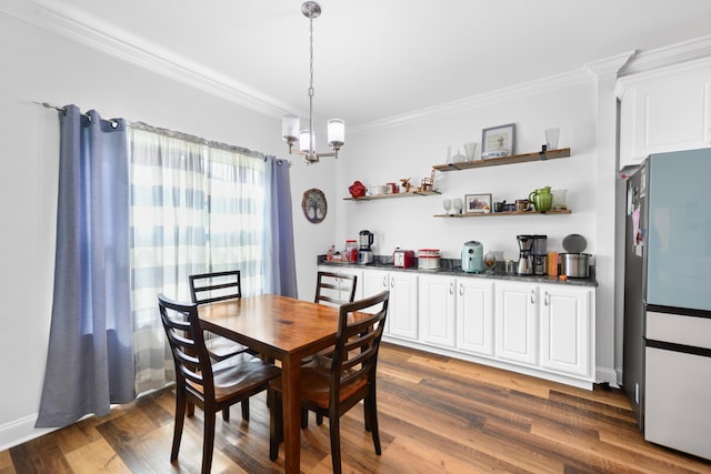 dining room featuring dark wood-type flooring, ornamental molding, and a notable chandelier