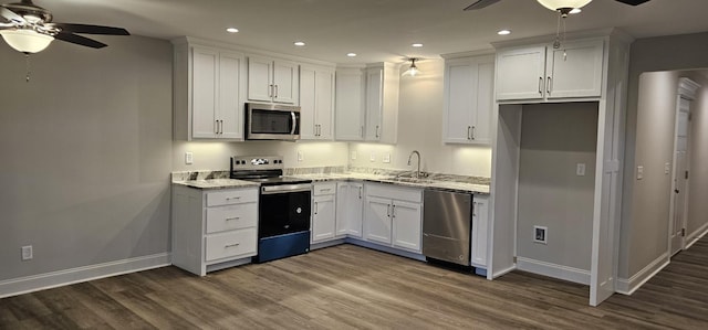 kitchen with light stone countertops, stainless steel appliances, white cabinetry, and dark hardwood / wood-style floors