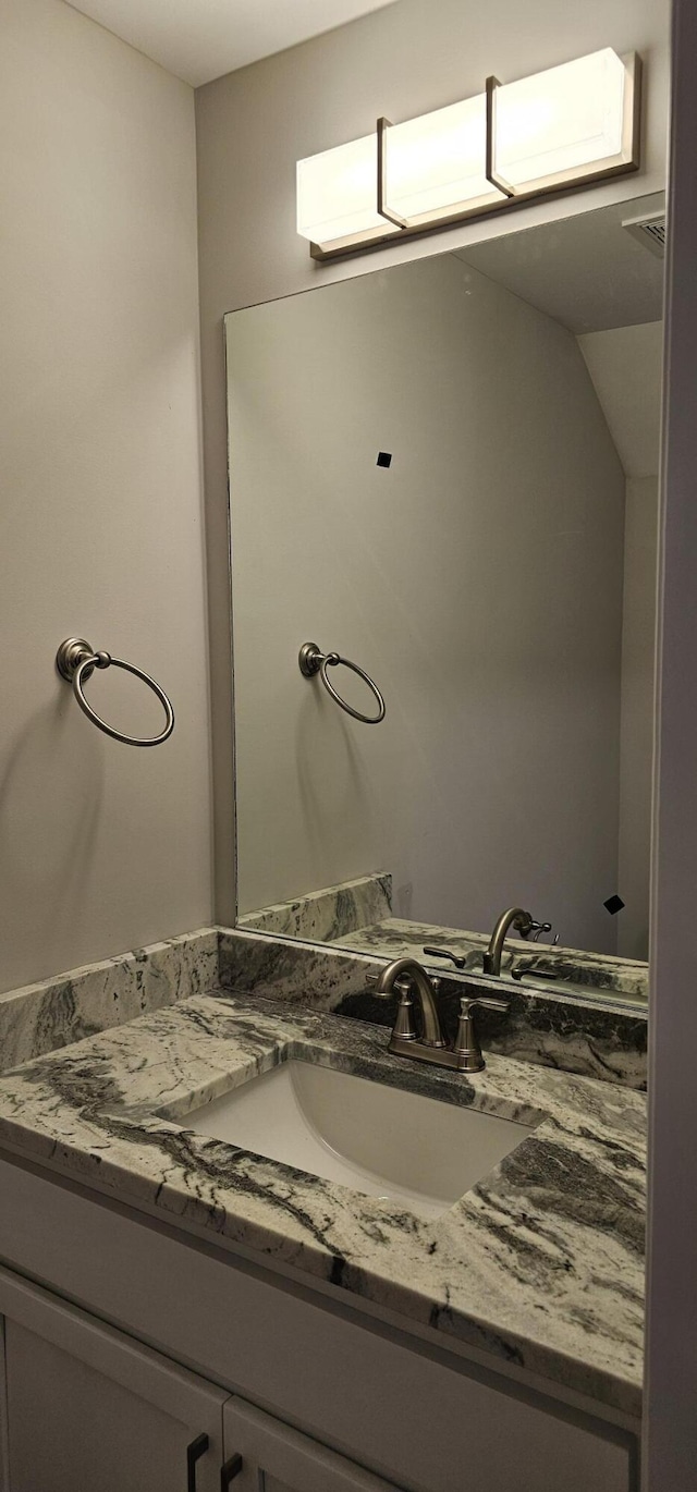 bathroom featuring lofted ceiling and vanity