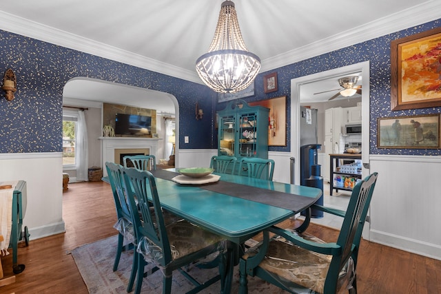 dining room featuring ceiling fan with notable chandelier, dark hardwood / wood-style floors, and crown molding