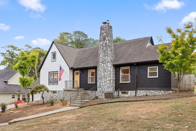 view of front of property with a front lawn and central AC