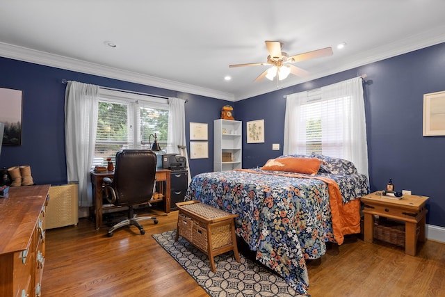 bedroom with ornamental molding, hardwood / wood-style floors, multiple windows, and ceiling fan