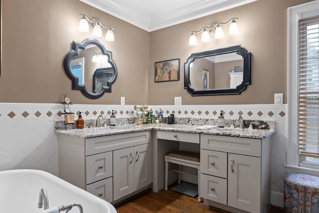 bathroom featuring tile walls, vanity, crown molding, hardwood / wood-style flooring, and a washtub