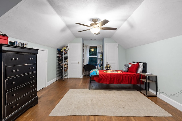 bedroom featuring ceiling fan, a textured ceiling, lofted ceiling, and dark wood-type flooring