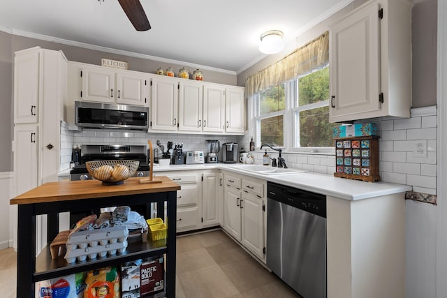 kitchen featuring decorative backsplash, white cabinets, appliances with stainless steel finishes, and sink