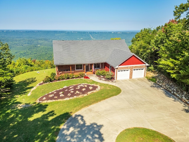 view of front of house with covered porch, a water view, a garage, and a front yard