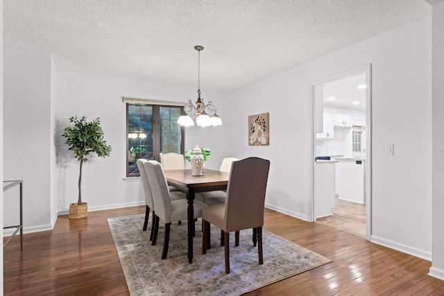 dining room featuring a textured ceiling, dark wood-type flooring, and a wealth of natural light