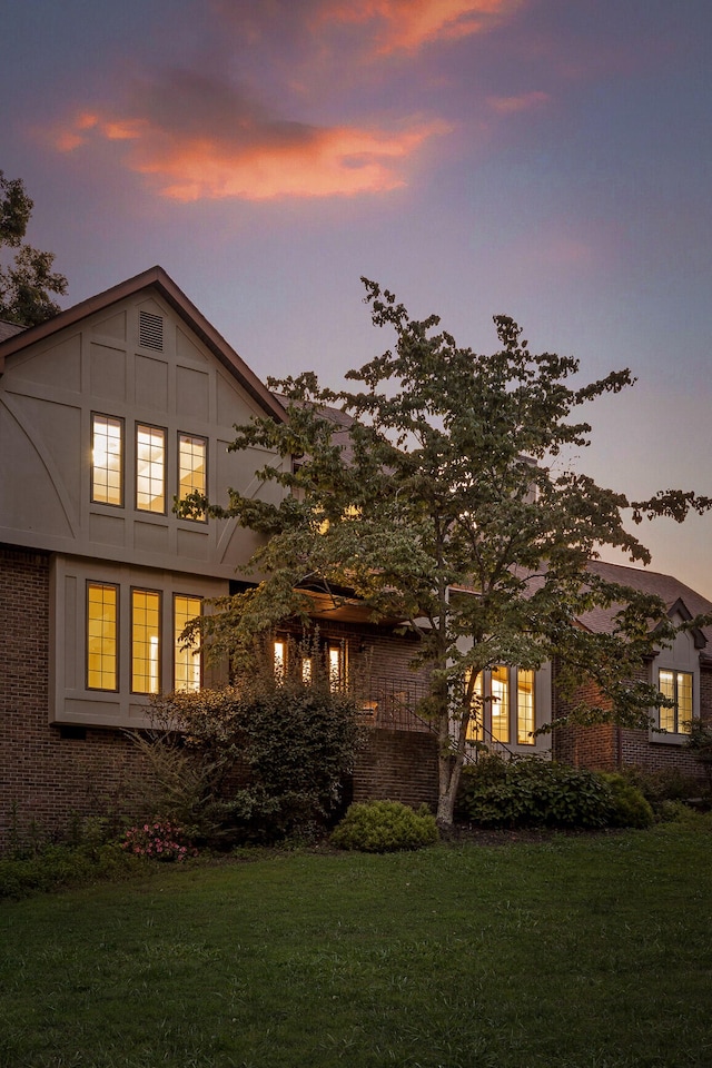 back house at dusk with a lawn