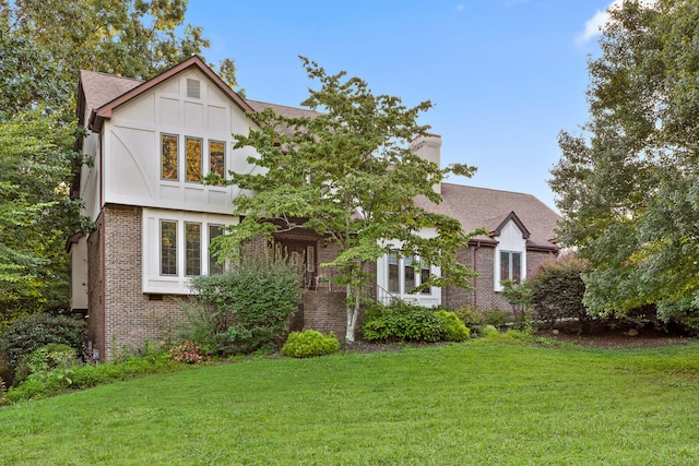 tudor-style house featuring a front yard