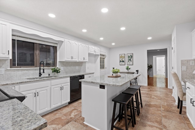 kitchen featuring decorative backsplash, white cabinetry, black dishwasher, a center island, and sink