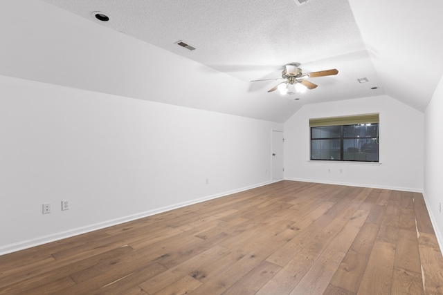 bonus room with vaulted ceiling, ceiling fan, hardwood / wood-style flooring, and a textured ceiling