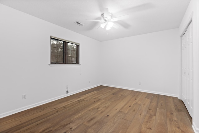 unfurnished bedroom featuring ceiling fan, a closet, and hardwood / wood-style floors