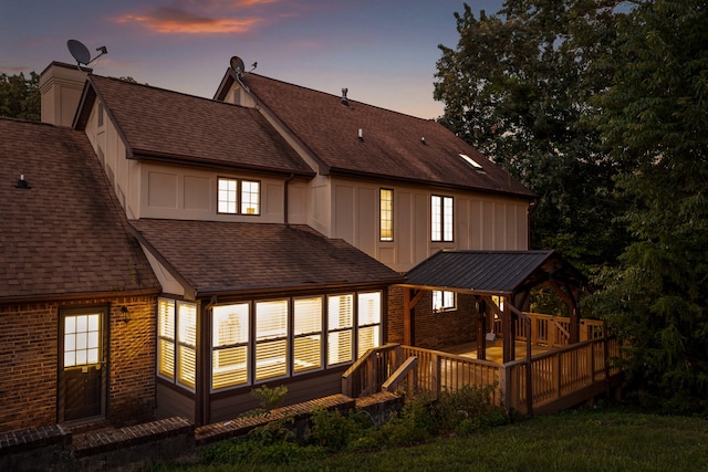 back house at dusk with a wooden deck