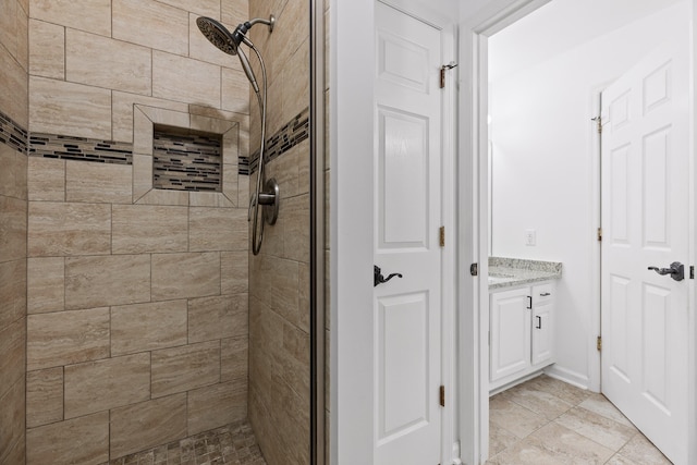 bathroom featuring a tile shower and vanity