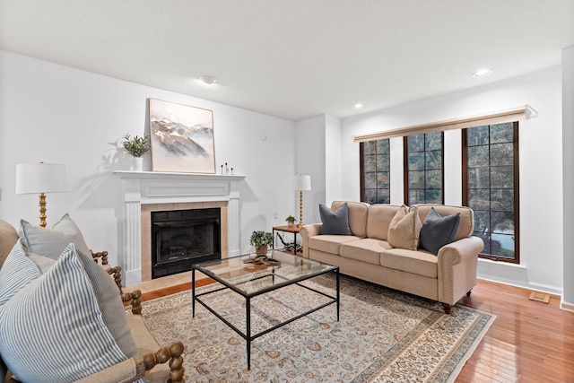 living room featuring light hardwood / wood-style floors and a tile fireplace