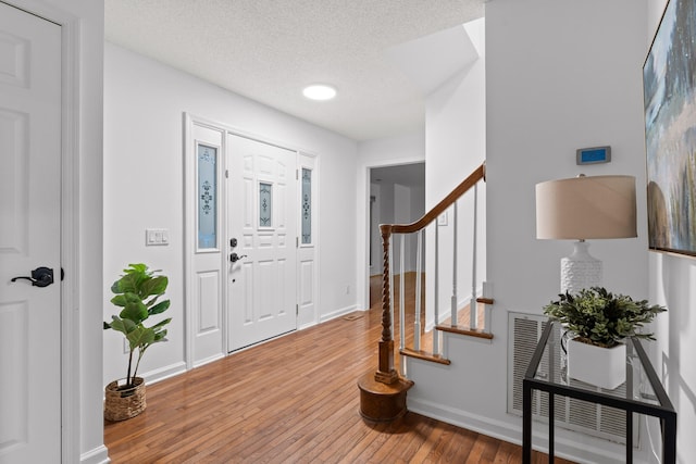 entrance foyer featuring a textured ceiling and hardwood / wood-style floors