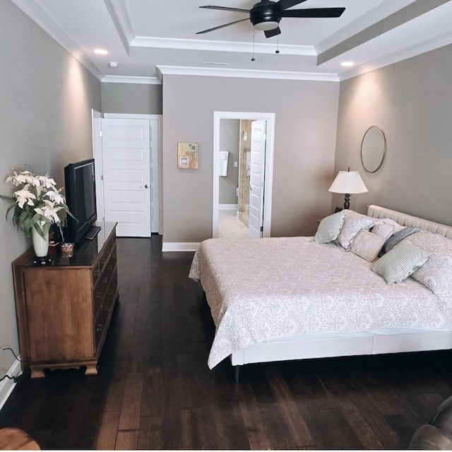 bedroom featuring ceiling fan, a raised ceiling, ensuite bath, and dark hardwood / wood-style flooring