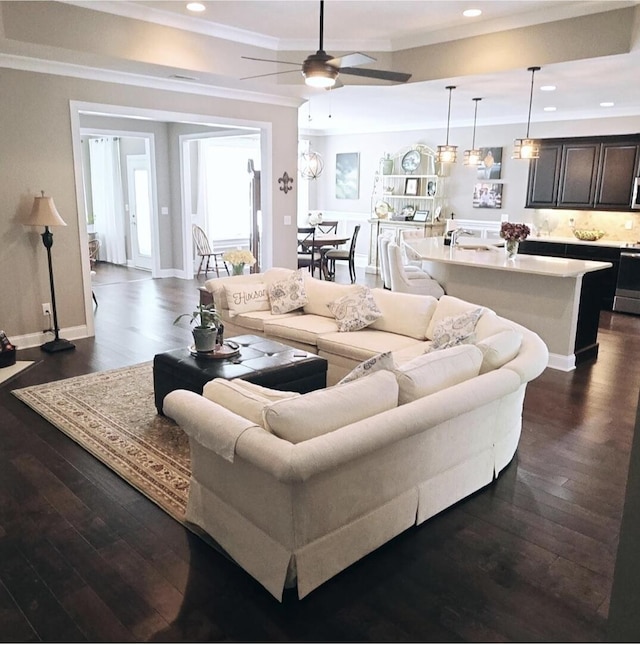 living room with ceiling fan, crown molding, and dark hardwood / wood-style flooring