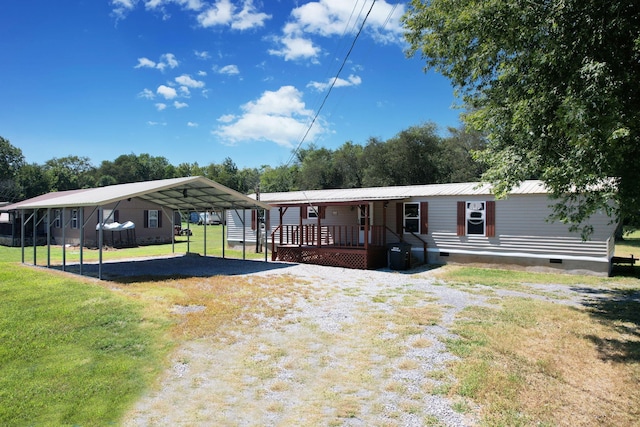 rear view of house with a lawn, a carport, and a deck