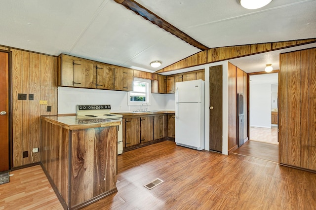 kitchen with wooden walls, lofted ceiling with beams, light hardwood / wood-style floors, and white appliances