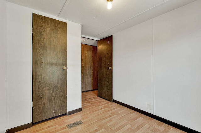 unfurnished bedroom featuring light hardwood / wood-style flooring and a closet