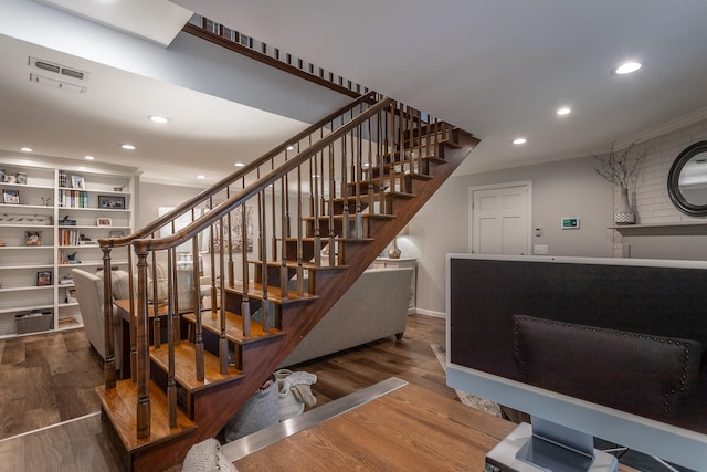 staircase with crown molding and hardwood / wood-style flooring