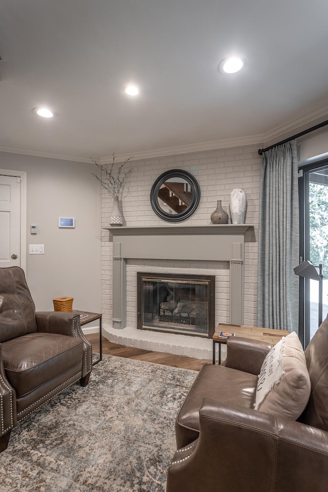 living room with wood-type flooring, a fireplace, and ornamental molding