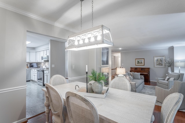 dining room with ornamental molding and light hardwood / wood-style flooring