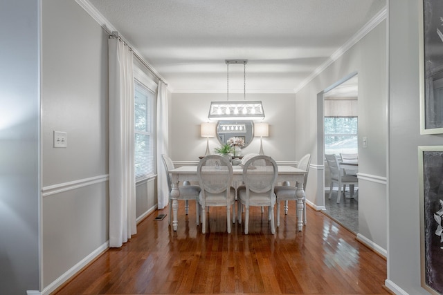 dining room featuring a notable chandelier, a textured ceiling, crown molding, and dark hardwood / wood-style flooring