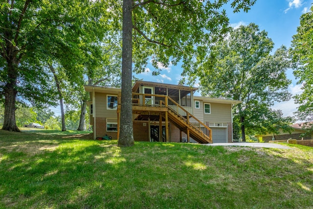 rear view of house with a garage and a yard