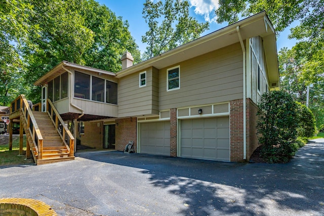 view of front of home with a sunroom and a garage