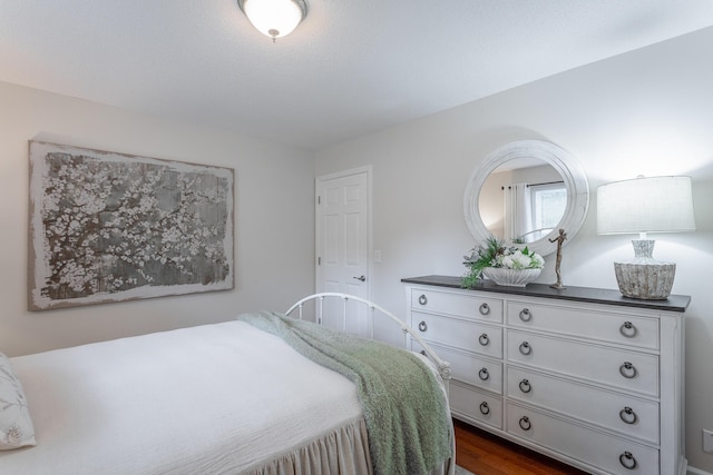 bedroom with dark hardwood / wood-style flooring