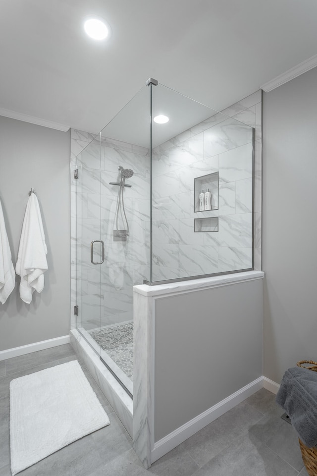 bathroom with crown molding and a shower with door