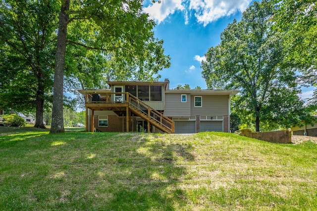 rear view of property with a garage, a sunroom, a yard, and a deck