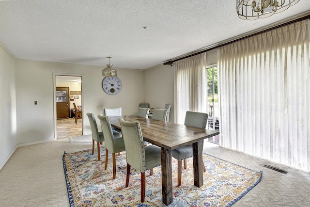 dining area with a textured ceiling and an inviting chandelier