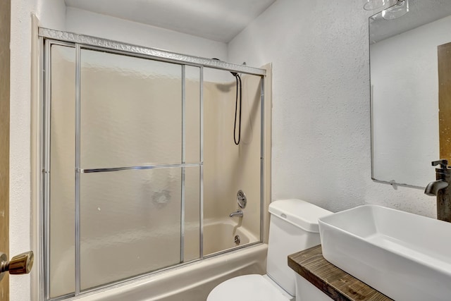 full bathroom featuring toilet, enclosed tub / shower combo, and sink