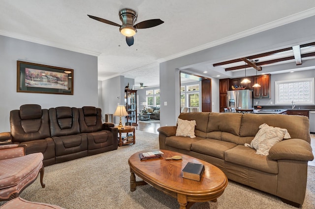 living room with ceiling fan, a textured ceiling, light carpet, and ornamental molding