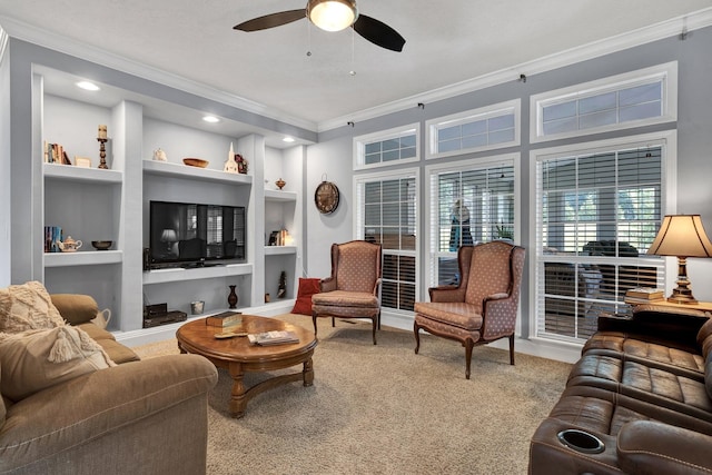 carpeted living room with ornamental molding, ceiling fan, and built in features