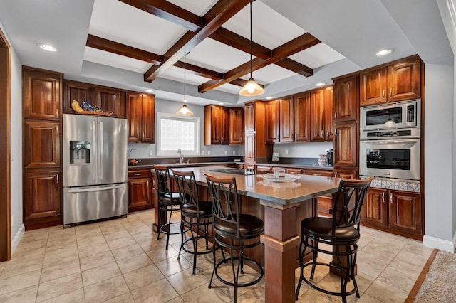 kitchen with a center island, beamed ceiling, coffered ceiling, stainless steel appliances, and decorative light fixtures