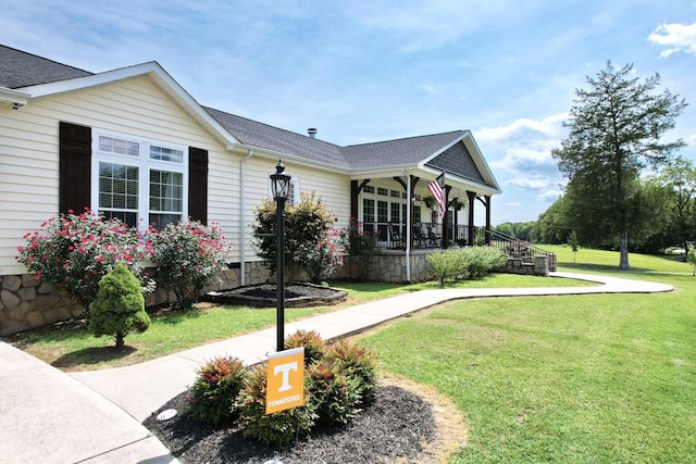 view of side of property featuring a yard and covered porch