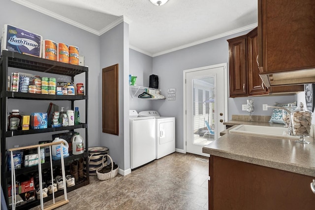 kitchen featuring a textured ceiling, crown molding, dark brown cabinets, sink, and washer and dryer