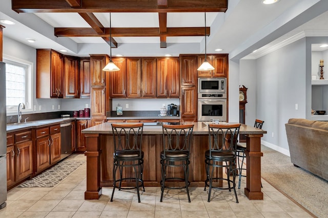 kitchen with a center island, appliances with stainless steel finishes, hanging light fixtures, and light tile patterned flooring