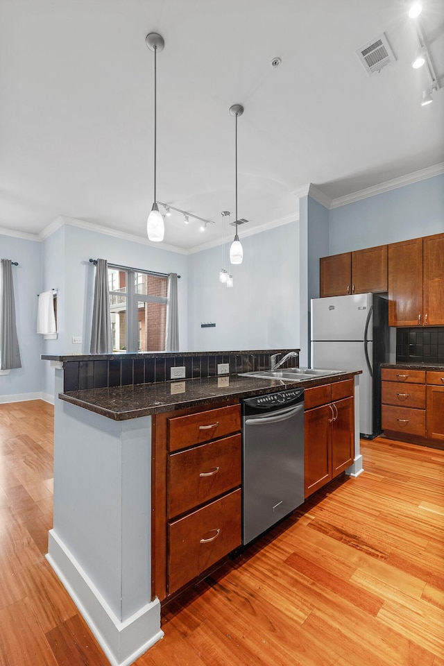 kitchen featuring appliances with stainless steel finishes, hanging light fixtures, light hardwood / wood-style floors, and crown molding