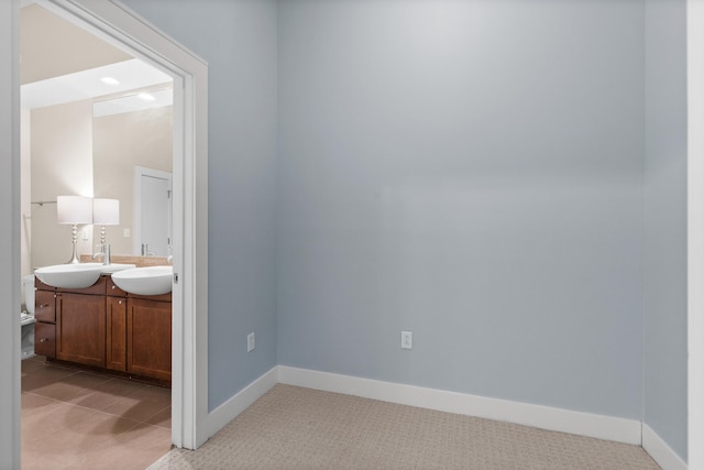 unfurnished bedroom with sink and light colored carpet