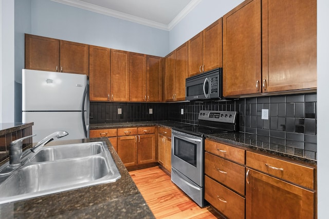 kitchen with decorative backsplash, light hardwood / wood-style floors, stainless steel appliances, ornamental molding, and sink