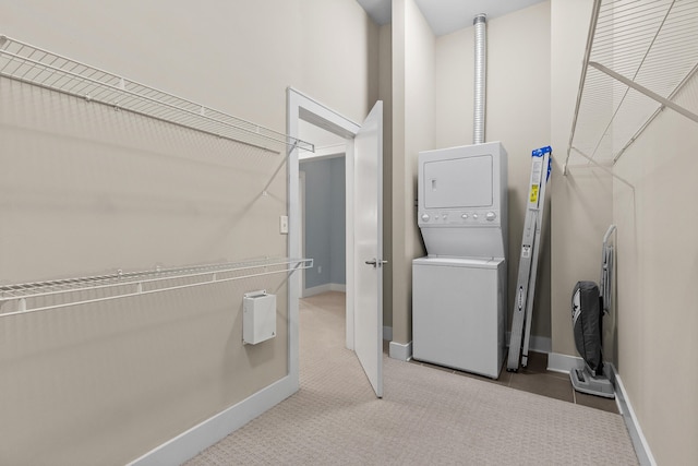 spacious closet featuring light carpet and stacked washer and clothes dryer