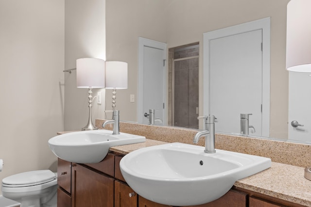 bathroom featuring vanity, toilet, and a shower with door