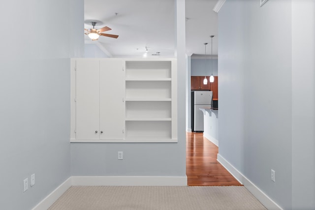 spare room featuring ceiling fan, crown molding, and light carpet